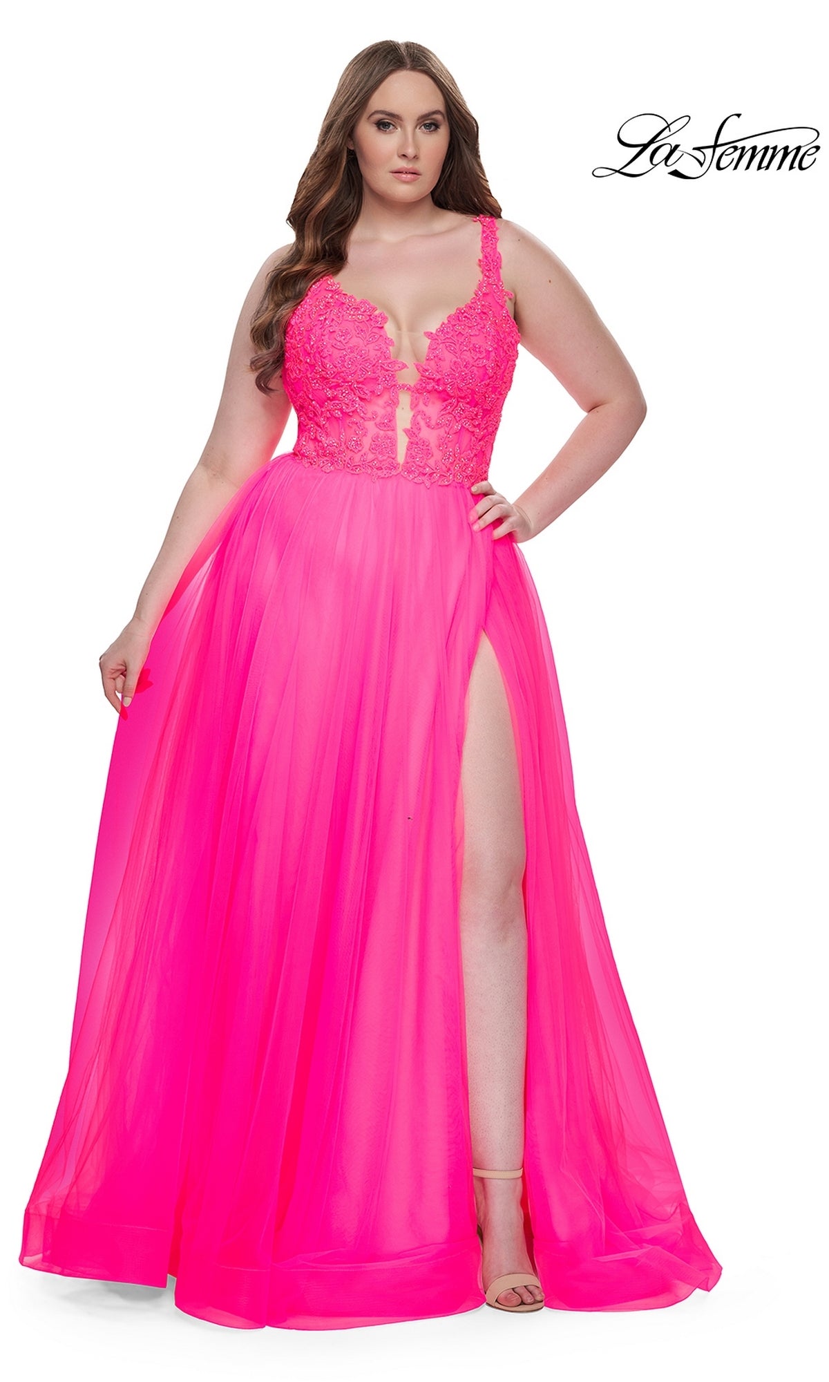 A woman poses against a white background wearing the La Femme Long Prom Dress 31394—a bright pink sleeveless ball gown with an embroidered lace bodice, deep neckline, high leg slit, and full, flowing skirt.